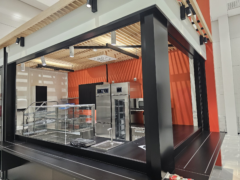 Raahen liikuntahalli: kahvion mustat peltikotelot ja listoitukset.